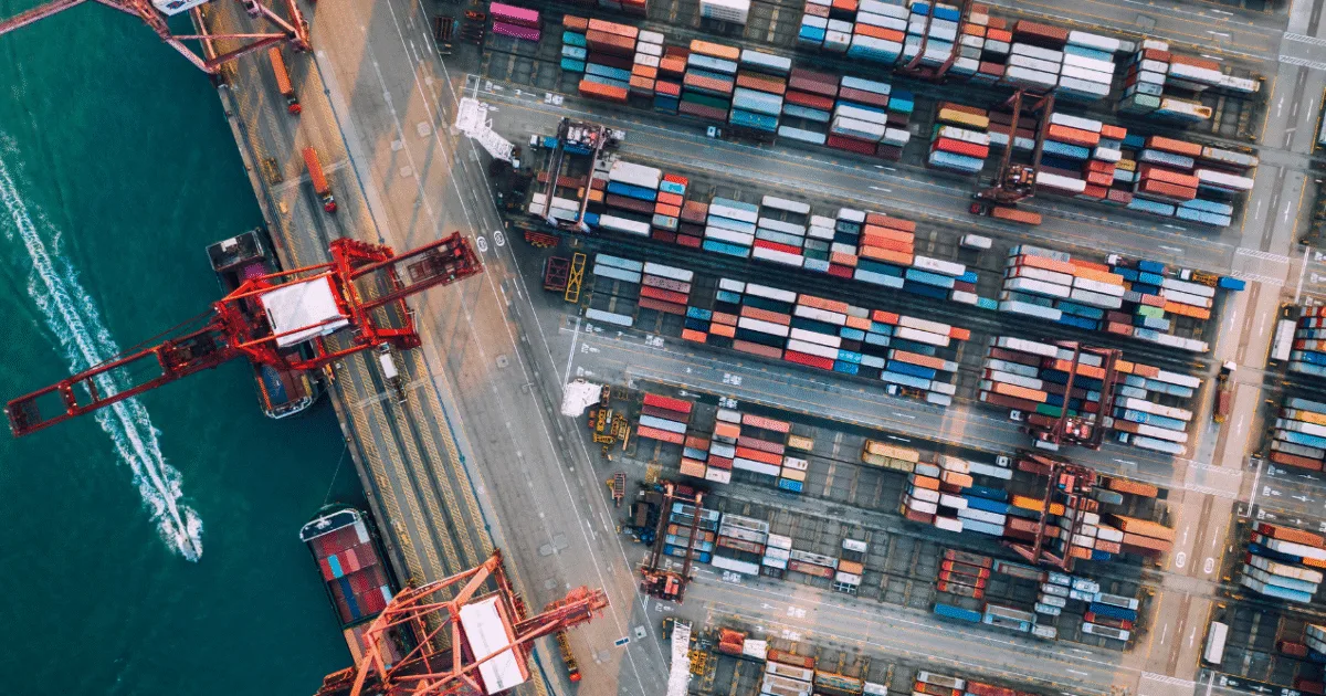 Entrepreneur analyzing profits from importing products from China with cargo containers and business charts